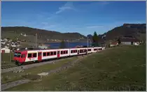 Kurz nach Les Charbonnières ist der TRAVY Regionalzug 6019 auf dem Weg nach Le Brassus. Der Zug besteht aus dem führenden Steuerwagen ABt NPZ DO TR 50 85 39-43 984-6 CH-TVYS, dem nachfolgenden Zwischenwagen B NPZ DO TR 50 85 29-43 384-1 CH-TVYS und dem schiebenden TRAVYS RBDe 560 384 (UIC RBDe 560 DO TR 94 7 560 384-0 CH-TVYS). Im Hintergrund ist der Lac Brenet zu erkennen. 

14. November 2020