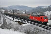 Schnee am Bözberg und dazu eine für den entsprechenden Farbtupfer passende Lok: 185 587-3 der RheinCargo ist mit Staubsilowagen nach Siggenthal (via Wettingen) unterwegs, aufgenommen am 10.12.2020 bei Zeihen AG.