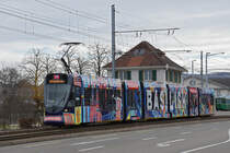 Be 6/10 Tango 185 mit der Werbung für das Radio Basilisk, auf der Linie 11, verlässt die Haltestelle M-Parc. Die Aufnahme stammt vom 21.01.2021.