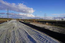 Bahnverlegung Sande. Neubaustrecke (NBS)rund um Sande. 
Im Zuge des zweigleisigen Ausbaus und der Elektrifizierung der Bahnstrecke Oldenburg(Oldenburg)-Wilhelmshaven entsteht rund um Sande eine ca. 4,7 Kilometer lange zweigleisige Neubaustrecke.
Diese ersetzt in diesem Teil die alte eingleisige Nebenbahn Sande-Jever-Esens (Teilstrecke der ostfriesischen Küstenbahn, die hier im Hintergrund verläuft. 
Die Strecke wird bis zum Abzweig des Industriestammgleises Wilhelmshaven (nach Ölweiche, Tanklager und JadeWeserPort) zweigleisig und elektrifiziert ausgebaut.

2021-03-19 Schortens Neu-Abbickenhausen