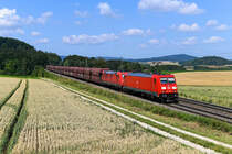 Mehrmals am Tag lassen sich auf der KBS 880 Ganzzüge bestehend aus Waggons der Gattung Falns beobachten, mit denen Kohle oder Erz nach Österreich befördert werden. Die Traktionierung obliegt stets Loks der Baureihe 185 von DB Cargo. Exemplarisch ist hier eine Aufnahme vom 21. Juli 2021 zu sehen: Die frisch revisionierte 185 214 und eine weitere Lok der Baureihe beförderten den GM 47933 vom Hansaport nach Linz Stahlwerke und konnten bei Darshofen in der Oberpfalz fotografiert werden. 