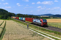 Der Radfahrer war sichtlich erstaunt, als er auf seiner Tour nach Parsberg eine Armada Fotografen am Feldrand erblickte. Der Sinn der Veranstaltung wurde ihm klar, als er von der SBB Cargo 193 464 mit dem Containerzug DGS 88129 von Dradenau nach Regensburg Ost überholt wurde. Entstanden ist die Aufnahme am 21. Juli 2021 bei Darshofen in der Oberpfalz. 