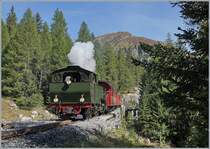 Von Realp kommend hat die HG 4/4 704 mit ihrem Dampfzug die baumlose Hochgebirgslandschaft hinter sich gelassen und fährt wenige Kilometer vor ihrer Ankunft in Oberwald durch eine Waldstück. 

30. September 2021