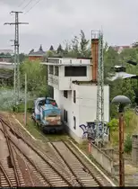 Neben bzw. unter dem ehemaligen elektromechanischen Weichenwärter-Stellwerk  W24  in Cottbus Hbf ist die Werkslok Nr. 4 (98 80 3201 067-6 D-AHG | 110 067-6 | DR V 100 067) abgestellt.
Aufgenommen von der Brücke Bahnhofstraße.

🧰 AHG Industry GmbH & Co. KG
🕓 28.8.2021 | 10:31 Uhr