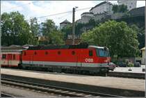 Die Bludenzer 1044 110 steht mit einer Schlierengarnitur auf dem Seitengleis in Kufstein. Oberhalb der Lok trohnt die Festung Kufstein.