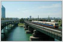 F�r eine Sonderfahrt am 18.8.2007 von Leopoldau nach Wolfsthal und wieder retour wurde ET 4030.210 von Wien Praterstern nach Leopoldau als Lp 32398 �berstellt. Die Aufnahme entstand bei der Querung der Donau zw. Handelskai und Floridsdorf. Links am Bild ist der 171 Metern (202 m incl. der Turmspitze) hohe Millennium Tower zu sehen. Interessant die Daten der 15.000 m� gro�en Verglasung. Die Einzelscheiben des dreiteiligen Verbundglases bestehen aus Floatglas mit einer Glasdicke von 34 mm. In gef�hrdeten Teilbereichen wurde zum Schutz vor Durchbruch die Au�enscheibe durch Verbundsicherheitsglas ersetzt. Erstmals kam in �sterreich das rationelle, kostensparende  Stahlbundverfahren  zum Einsatz. Statt drei Wochen f�r ein Gescho� wurde beim Millenium Tower lediglich eine Woche f�r zwei Stockwerke ben�tigt. 1999 war er fertig.
3.300 m� B�rofl�che bieten sich im 50gescho�igen Geb�ude an. Weiters findet man darin einen Kindergarten, ein �rztezentrum sowie 425 Wohnungen und ein Einkaufszentrum.
