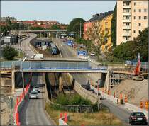 Grüne Linien, zwischen Thorildsplan und Fridhemsplan - 

Blick nach Westen auf die T-Bahn-Trasse in der Drottingsholmvägen. Im Hintergrund die Station Thorildsplan. Der U-Bahnzug aus Richtung Hässelby strand kommend wird gleich in den Felstunnel mit der Station Fridhemsplan unter Kungsholmen einfahren. 

Die Strecke von Vällingby bis Hötorget wurde am 16.10.1952 eröffnet. 

29.08.2007 (M)