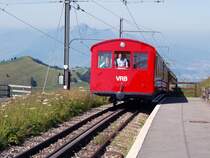 Ein Zug mit zwei Beiwagen kommt in Rigi Kulm an.