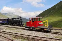 Im Hintergrund wartet die Lok BFD 9 (ex Brig-Furka-Disentis-Bahn) auf die Weiterfahrt Richtung Gletsch - Oberwald. Die Draisine 506 hat beim Gegenzug im Scheiteltunnel zwischen Muttbach-Belvédère und Furka Schiebedienst geleistet. Der Scheiteltunnel ist 1.8 km lang und die Steigung beträgt in der erwähnten Fahrtrichtung während den ersten 1500 m 30 Promille. Es ist keine Zahnstange vorhanden. So kann übermässige Dampfentwicklung verhindert werden und im Notfall wäre eine Hilfslok bereits am Zugschluss. Das Foto wurde vom Publikumsbereich aus gemacht. Furka, 28.7.2022
