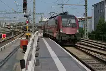 Bahnsteigerneuerung und Bahnbetrieb (|) - Am zweiten, bereits erneuerten Bahnsteig von insgesamt fünf zu erneuernden Bahnsteigen zieht 1116 154 die Wagen des RJ 890, Bregenz - Frankfurt (M), am 10.07.2023 in den Friedrichshafener Stadtbahnhof