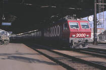 Eine Re 4/4 IV der SBB - dem Wappen nach könnte es die 10103 sein - wartet mit einem internationalen Schnellzug in Lausanne auf die Weiterfahrt nach Genf. Der zweite Waggon hinter der Lok hat Fenster zum Öffnen - könnte es vielleicht ein Liegewagen der SNCF sein? Oder doch ein UIC-Waggon der SBB?
Lausanne, 22. August 1987; Canon AE-1, Canoscan, Gimp