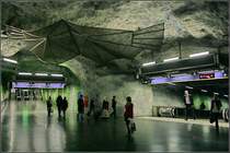 Blaue Linie, Stammstrecke, Station  Fridhemsplan  -  

Blick in die künstliche Höhlenwege unter Stockholm. Hier kreuzen sich die Fußgängertunnel. Nach rechts geht es auf Fahrtreppen hinunter zu den Bahnsteigen der Blauen Linie, geradeaus zum Südausgang des der Grünen Linie. Links außerhalb des Bildes führt der Stollen zur Station der Grünen Linie, im Rücken des Fotografen zum nördlichen Ausgang der Grünen Linie. Die Wege zum Umsteigen sind relativ weit. 

28.08.2007 (M)