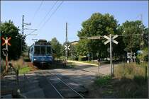 Roslagsbanan, Näsby - 

Blick auf einen Bahnübergang nähe der Station  Näsby allé . Die Roslagbanan verbindet Stockholm mit den nordöstlich gelegenen Kommunen. Die Streckenlänge (es gibt drei Streckenäste) beträgt 65,3 km. Einstmals war die Netzlänge 327 km. Die Spurweite beträgt 891 mm. Betrieben wird die Bahn heute von SL. In Stockholm enden die Züge an der Östra station. Dort kann mit der U-Bahn an Station  Tekniska Högskolan  weiter in die Stadt gefahren werden. 

21.08.2007 (M)