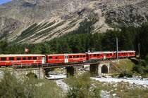 RhB Regionalzug 1439 von St.Moritz nach Tirano am 25.08.2007 in Morteratsch mit Triebwagen ABe 4/4 III 54 - ABe 4/4III 52 - BD 2477 - AB 1545 - B 2466 - B 2463 - B 2233 - B 2453 - B 2309. Hinweis: Teilzug auf Morteratschbach-Br�cke
