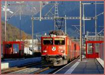 Im letzten Licht der untergehenden Sonne passiert Ge 6/6 II 701  Raetia  die Haltestelle Ems Werk. (17.12.2007)