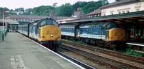 Am 5. September 1996 warten 37414 (links) und 37418 (rechts) in Bangor auf Weiterfahrt nach Crewe. Die Lokomotiven und Wagons tragen die Farben von der Regional Railways, einem Geschaeftsbereich von British Rail.