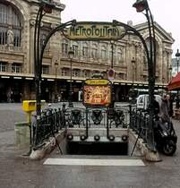 Paris, Gare du Nord, 16.02.2008. Ein ganz typischer Pariser Metro - Zugang mit feiner, schmiedeeisener Arbeit und dem  Metropolitain  - Schild. Nat�rlich d�rfen die roten Lampen nicht fehlen. Sch�n, dass Paris doch ein einziges, gro�es Museum ist.