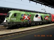 Bei sonnigem Wetter kommt die �beraus gelungene Farbkomposition der EM-L�nderlok besonders gut zur Geltung, so wie hier am 18.4.2008 auf dem Wiener S�dbahnhof vor einem Regionalzug nach Wiener Neustadt. Zu beachten ist auch der neue Aufkleber am hinteren Ende mit der Aufschrift  Umwelt am Ball . 