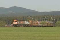 W�hrend die Zuglok - V330.3 - den h�chsten Punkt der R�belandbahn �berwunden hat und in die Gef�llestrecke geht, schiebt V330.2 noch kr�ftig nach. Nach dem �berwinden des Scheitelpunktes gibt sie ihre Schubleistung auf und wird ein paar Kilometer weiter, auf der 51 Promille-Rampe zwischen Elbingerode West und Elbingerode HBF, als Bremslok wirksam.
An dieser Stelle zweigte fr�her die Stichbahn nach Drei-Annen-Hohne ab. Ende der 60er Jahre wurde hier ein elektrifizierter Stich zum Schacht III der Eisenerzgrube B�chenberg gebaut. Hier sollten j�hrlich 1 Mio Tonnen Eisenerz �ber die R�belandbahn abtransportiert werden. Doch bevor das Schachtger�st gestellt wurde, kam �berraschend das Aus f�r den Elbinger�der Eisenerzbergbau. Neben der 70 Mio Mark Investruine wurden auch einige Maschinen der BR E251 zu viel gebaut und es stand nun dem BW Blankenburg ein Lokomotiv�berbestand zur Verf�gung. Da die Maschinen auf keiner anderen Strecke in der DDR eingesetzt werden konnten, wurde der �berbestand auch nicht abgezogen.