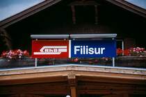 Stationsschild, eingerahmt von Holzgeb�ude und Blumenschmuck. Kein Wunder, dass soviele Menschen diese Bahn so lieben.