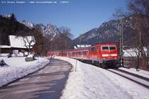 Noch im vergangenen Jahr wurden die Regionalbahnen (Salzburg -) Freilassing - Berchtesgaden mit Lok voraus bespannt, was am 23.2.03 diese Foto von der 111 035 im pr�chtigsten Sonnenschein in Bischofswiesen, dem Heimatort vom Hackl-Schorsch, erm�glichte.
Heute fahren die Garnituren  andersrum  und die Lok ist immer auf der lichtm��ig ung�nsigen Seite.