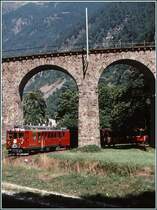 Nach der 360Grad Kurve �ber das Kreisviadukt von Brusio erscheinen die zwei ABe 4/4 II mit dem Bernina Express zwischen Edelkastanienb�umen in der unteren Br�cken�ffnung. (Archiv 09/89)