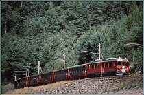 Unterhalb von Miralago bremst der ABe 4/4 III 53 einen Regionalzug talw�rts Richtung Tirano. Hier h�ngt noch die alte Holzmastenfahrleitung. (Archiv 09/89)