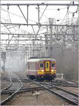 Die AM65 228.256 verl�sst am 27.02.09 den Bahnhof von Brugge mit den Spitzenlichtern am Ende des Zuges. (Jeanny)