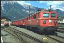 1110 011-2 Anfang der 90er in Innsbruck. Ob sie den Arbeitszug im Hintergrund zu ziehen hatte, oder nur dort abgestellt war, kann ich nicht mehr sagen. Jedenfalls hatte sie sich ein h�bsches Pl�tzchen mit Bergpanorama ausgesucht. 