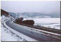D52 - dunkle Monster in düsterer Landschaft. Auf dem tief gefrorenen, in dichtem Nebel liegenden Hochplateau am Fusse des Vulkans Komagatake kommt die D52 468 mit einem Güterzug daher. Die Lok ist leider nicht im Detail sichtbar, aber der eisige See dahinter schon. 25.Dezember 1971.