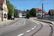 Saarbahn in Riegelsberg: Kurz vor der Haltestelle Rathaus wird die Strecke zweigleisig, die Strecke in Richtung Norden verl�uft in der Stra�enfahrbahn. Der Bahnsteig ist auf dieser Seite f�r ein Hofeinfahrt kurz unterbrochen. Noch fehlt die Haltestellen-Ausr�stung. 23.05.2009 (Matthias)