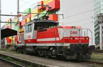 Bunte Lok vor buntem Hintergrund. 1163 011 am 1. Mai 20098 in Salzburg Hbf.