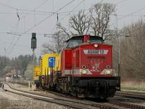 Die V 100 von Uwe Adam am 04.04.2009 mit einem Bauzug bei der Durchfahrt in A�ling.
