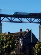 �ber den D�chern von Moresnet in Belgien rollt eine BR 186 mit einem G�terzug und eingezogenen Stromabnehmern durch die Systemtrennstelle Richtung Aachen �ber das 1153m lange G�hltalviadukt