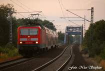 Im letzten Licht beschleunigt 143 642-7 mit RB 28033 Wustermark - Potsdam Hbf. aus dem Haltepunkt Marquardt,hinter der Br�cke liegend (01.07.09)