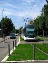 Ein Bild einer modernen franz�sischen Stadt: In der Mitte der Strasse f�hrt  le tramway  auf seinem begr�nten Eigentrasse, links und rechts zirkulieren auf vielerorts verkehrsberuhigten Strassen haupts�chlich Fahrr�der und ab und zu ein Auto. So auch hier im els�ssischen Strasbourg zwischen den Haltestellen Ducs d'Alsace und St Florent auf der Linie A. (5.August 2009)