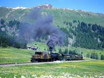 RhB Dampfextrazug mit Krokodilvorspann f�r GRAUB�NDEN TOURS 3031 vom 20.06.1999 in der Steigung kurz vor Davos Wolfgang mit E-Lok Ge 6/6I 411 - G 4/5 107 - B 2245 - B 2246 - A� 1102 - C� 2012 - D� 4052II - B� 2060 - B� 2102 - B� 2092. Hinweis: Am Zugende laufen bei Dampfz�gen selten gesehene offene gelbe Bernina-Aussichtswagen mit!