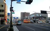 Matsuyama Strassenbahn, Serie 62-69: In den letzten Strahlen der Abendsonne bef�hrt Wagen 68 eine einspurige Querverbindungsstrecke. Als die Insel Shikoku nur �ber die F�hre zu erreichen war, gab es noch keine solchen grossen Strassen. Honch� Goch�me, 17.September 2009. 