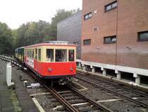 Ein Zug aus drei Bauzust�nden der Hamburger T-Wagen ( TU 1, T, TU 2 ) f�hrt am 11.10.2009 in den Bahnhof Schlump ein. Der T-Wagen in der Mitte des Zuges ist der Ursprungszustand aus den Gr�ndungsjahren der Hochbahn. Der TU 1 an der Spitze ist ein Wiederaufbau kriegszerst�rter T-Wagen. Beim TU-2 am Zugschlu� handelt es sich um einen modernisierten T-Wagen der j�ngsten Lieferung aus den zwanziger Jahren des vorigen Jahrhunderts. Es wurde jeweils nur der Aufbau ver�ndert. Die Technik wurde beibehalten um alle Bauformen frei miteinander kuppeln zu k�nnen. Die Fahrzeuge waren bis Ende der siebziger Jahre im Liniendienst. 