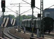 Der Sonderzug mit historischen Wagen zum Bahntag in Elstal f�hrt am 21.5.2005 aus dem Bahnhof Berlin Spandau nach Ruhleben zum Wenden. Geworben wurde mit einer 52er Dampflok. Doch die wurde schadhaft. Als Ersatz fuhr ein E-Lok. Rabatt gab es daf�r aber nicht! Im Hintergrund die  Innovative 7gleisige Br�cke �ber die Havel . Die unm�glichste Eisenbahnbr�cke in Deutschland. Sie will beim Befahren abheben und mu�te deshalb r�ckverankert werden. Mehrkosten ca 8 Mio DM, die sich die Stadt Berlin und die Deutsche Bahn teilten