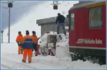 Auch der Spurpflug muss mit Muskelkraft wieder flott gemacht werden. Der Grund der Schneeverwehungen sind die orkanartigen St�rme hier oben, die im Hintergrund an der Bergflanke sch�n zu sehen sind. Und es ist saukalt in Ospizio Bernina und das Restaurant ist auch geschlossen brrr...(01.12.2009)