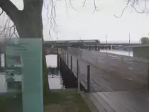 2001 wurde der Holzsteg parallel zum Rapperswiler Seedamm er�ffnet. Beim Start dieses Holzstegs ist eine Infotafel montiert, die �ber die Geschichte der Rapperswiler Seequerung informiert. 1878 fuhr die erste Eisenbahn �ber den Seedamm. Allerdings verlor der Seedamm von seinem Glanz, und wird heute t�glich in den Verkehrsmeldungen am Radio er�whnt, wie sehr sich der Verkehr vor Rapperswil staut. Daneben f�hrt schier unscheinbar eine S5 Dotra nach Rafz �ber den Z�richsee am 26.11.09.