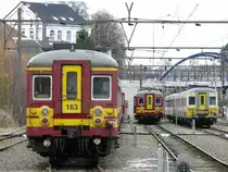 Belgische Altbautriebwagen im Bahnhof Welkenraedt (im Hintergrund erkennt man das alte Kasino von Herbesthal). Links und in der Mitte 163 und 155 (beide AM 62) und rechts 736 (AM78). Die Fahrzeuge der Baureihe AM78 werden nach und nach in Mechelen modernisiert, w�hrend sich die Dienstzeit der �lteren Baureihen langsam dem Ende zuneigt. Aufgenommen am 29/11/2009. Die Aufnahme entstand am Ende des Bahnsteigs.  