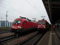 Die BR 182 mit dem Fu�ballsonderzug neben der BR 101 105, die an einem IC h�ngt. Fast kaum erkennbar: Der Tf der 182 h�lt ein Zuglaufschild f�r die RE-Linie 10 Leipzig-Cottbus ans Fenster. Eine Anspielung auf das aktuelle Einsatzgebiet der BR 182
Rostock, 14.12.09