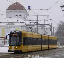 Gelber Auftritt im Wintergrau - NGTD8DD auf Linie 9 f�hrt vor der Kulisse des Schauspielhauses auf die Hst. Postplatz/Wallstra�e zu (02.01.2010).