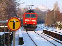 185 127-8 zieht langsam einen Kesselzug von Aachen West kommend in die Haltestelle Schanz. Dieser Teil der Strecke richtung Kln geht ber Brcken und Viadukte mitten durch die Stadt. Im Hintergrund kann man den Pulverturm an der Turmstrasse in Aachen erkennen.