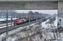 In migem Tempo rollen die zu HGK gehrenden 185 606-1 & DE 670 samt Kesselzug der Stadtgrenze Berlins entgegen und passieren hier eine der unzhligen Brcken ber die Schnellfahrstrecke Berlin - Hannover,bei Dallgow-Dberitz am 05.01.10