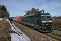 185-551 der MRCE in der warmen Mittagssonne mit einem Containerzug.(KBS 880,bei Parsberg,27.02.2010)