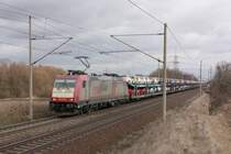 Etwas buntes vor dem grauen Himmel. Crossrail 185 599-8 mit einem Ganzzug Autotransportwagen am Stadtrand von Magdeburg, die Fahrt ging in Richtung Braunschweig. Fotografiert am 14.03.2010. 