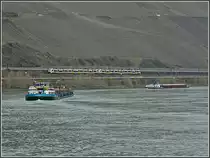 Bei regem Schiffsverkehr und m��igem Wetter f�hrt eine Trans Regio Doppeleinheit ET 460 auf der linken Rheinstrecke in der N�he von Boppard an den noch kahlen Weinbergen vorbei. (Hans)  